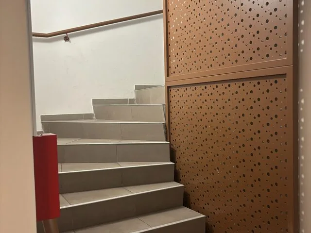 Escalier intérieur avec habillage mural en tôle perforée corten