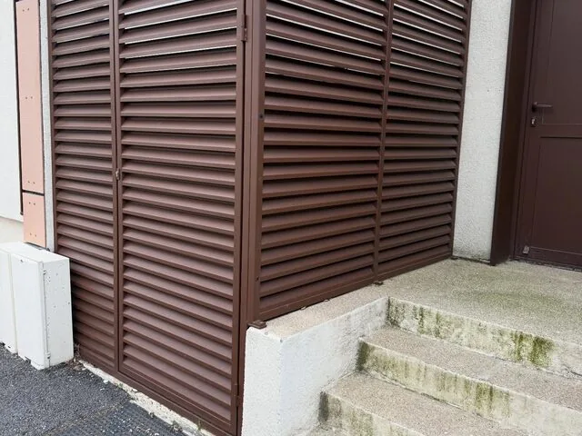 Habillage technique ajouré brun en angle de façade