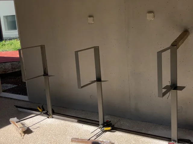 Supports métalliques sur mesure fixés sur mur béton, pose en cours