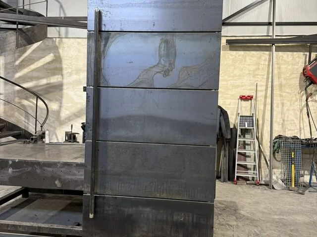 Grand vantail technique en acier brut suspendu, fabrication à l’atelier