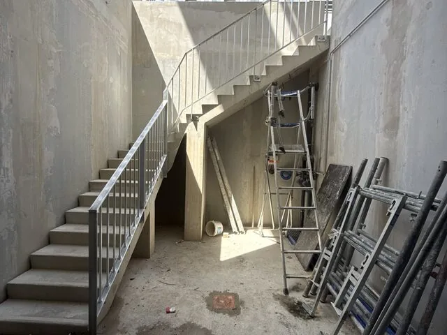 Garde-corps tubulaire le long d’un escalier extérieur en béton, chantier en cours