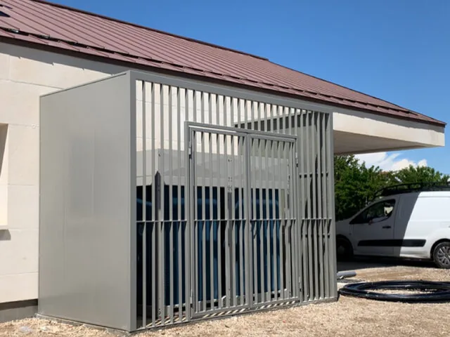 Habillage technique ajouré gris autour d’un groupe extérieur