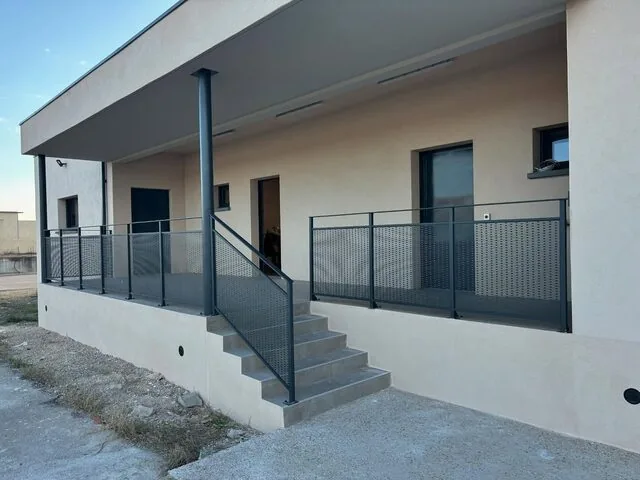 Garde-corps à panneaux perforés gris le long d’un escalier extérieur