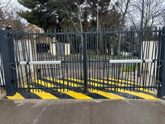 Portail à barreaudage noir grand ouvert, accès poids lourds